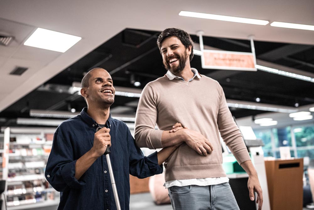 Adult man visually impaired talking with friend at university