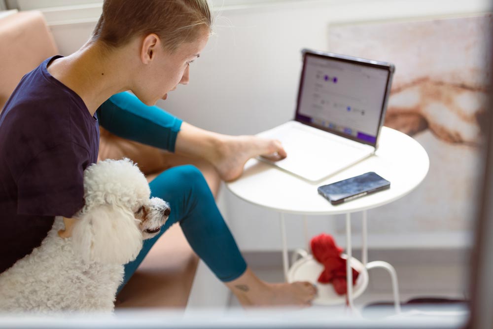 Girl with a disability (phocomelia) working on a laptop with her feet